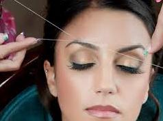 woman having eyebrows threaded 